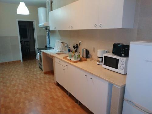 ポルトにあるML Apartments Bolhão Deluxeのキッチン(電子レンジ、冷蔵庫付きのカウンター付)