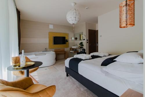 Habitación de hotel con cama y bañera en Baobab Suites en Siófok