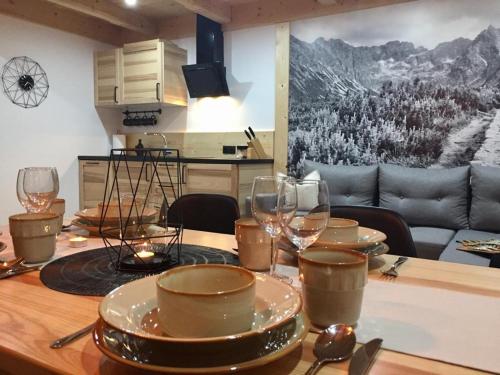 Una mesa con platos y copas de vino encima. en Domek Góralski u Basisty, en Poronin