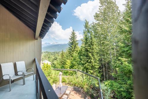 a balcony with two chairs and a view of the mountains at The Ironwood on Blueberry Hill in Whistler