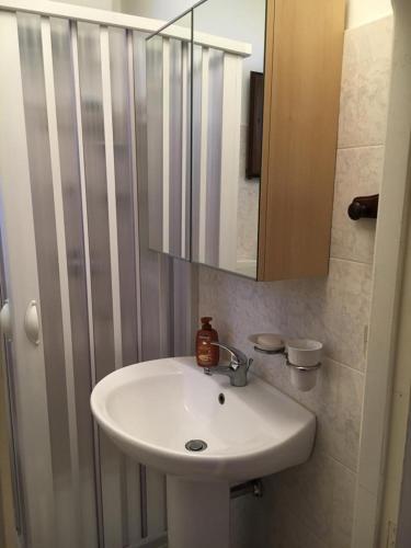 a bathroom with a white sink and a mirror at Casa Vacanze " MELA " in Nova Siri