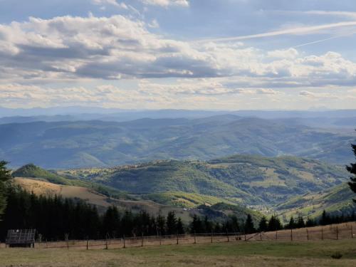 a view of a valley from a hill with a fence at Home Belić Golija in Radaljica