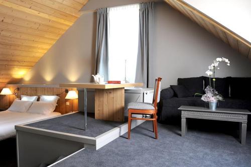 sypialnia z łóżkiem, biurkiem i kanapą w obiekcie Hôtel d'Angleterre w mieście Arreau