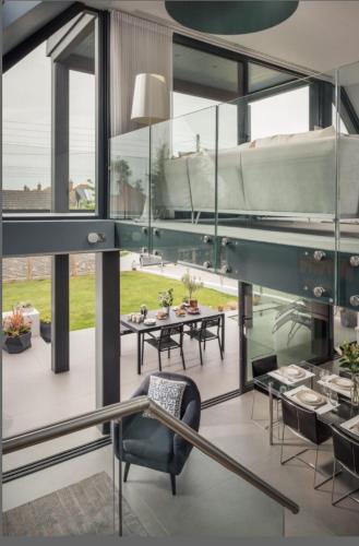 a room with a table and chairs and windows at Oyster Shell Whitstable in Whitstable
