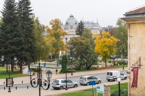 una calle con coches estacionados frente a un edificio en Charlino Plaza, en Ruse