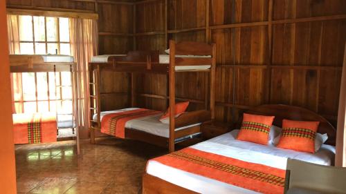 a room with two bunk beds in a cabin at Hotel Villas Vista Arenal in Fortuna