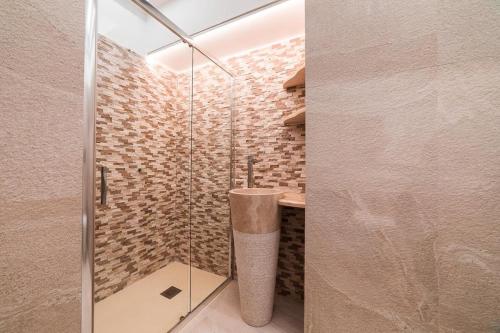 un bagno con doccia con porta in vetro di Le Esperidi a Ravello