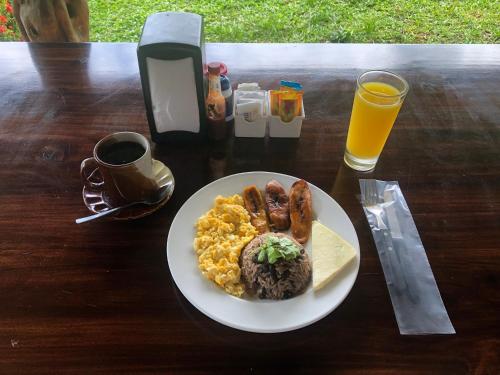 Hotel Villas Vista Arenal في فورتونا: طبق من طعام الإفطار مع البيض ولحم الخنزير المقدد على الطاولة