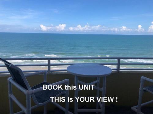 a table and chairs on a balcony overlooking the ocean at Ocean Walk Resort - Remarkable Ocean Front View in Daytona Beach