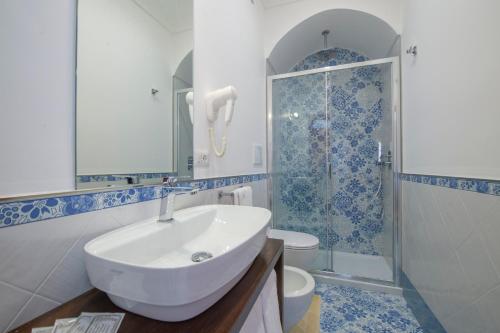 a bathroom with a sink, toilet and bathtub at Open Gate in Praiano