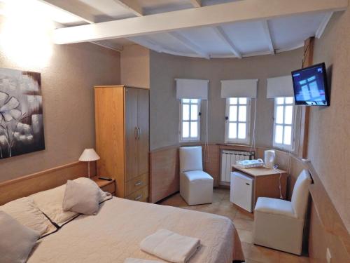 Un dormitorio con una cama, un escritorio y un televisor. en Pinamar Centro Departamentos NO GRUPOS DE JOVENES, en Pinamar