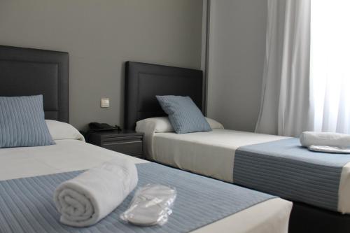 a hotel room with two beds with towels on them at Hotel Barajas Plaza in Madrid