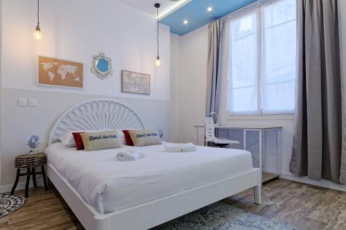 ein Schlafzimmer mit einem weißen Bett und einem Fenster in der Unterkunft La Perle Marine - 5 min à pied de la Canebière in Marseille