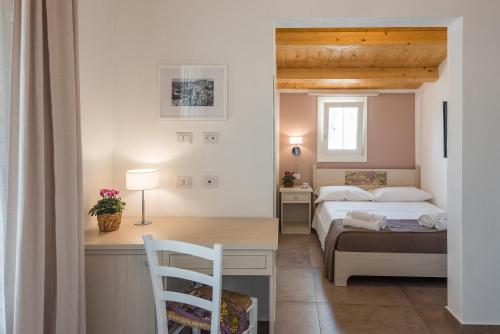 sypialnia z łóżkiem i biurkiem z krzesłem w obiekcie Il Baiocco w mieście Ragusa