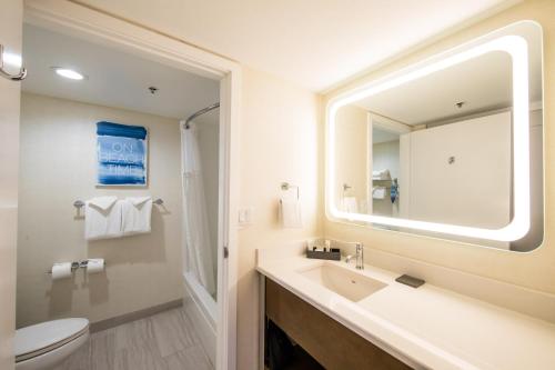 a bathroom with a sink and a toilet and a mirror at SeaCrest Oceanfront Hotel in Pismo Beach