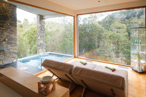 een kamer met een groot raam met uitzicht op een zwembad bij Peppers Cradle Mountain Lodge in Cradle Mountain