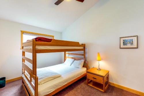 a bedroom with a bunk bed and a table with a lamp at DuHaus Green in Big White