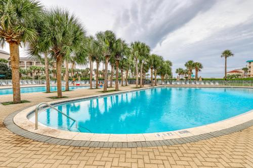 a large swimming pool with palm trees in a resort at Amalfi Coast in Miramar Beach