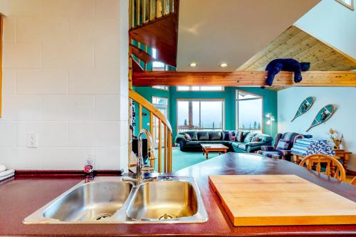 a kitchen with a sink and a living room at DuHaus Green in Big White