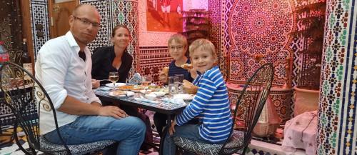 a group of people sitting at a table with a child at Riad Fes Touria Palace in Fès