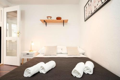 een slaapkamer met een groot bed met witte handdoeken bij House Heritage in Stari Grad