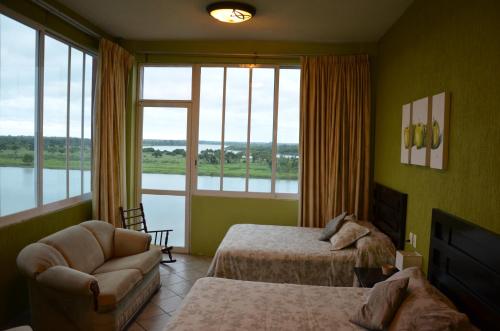 a bedroom with two beds and a large window at Hotel Santa Luisa Finca Boutique in Tecolutla