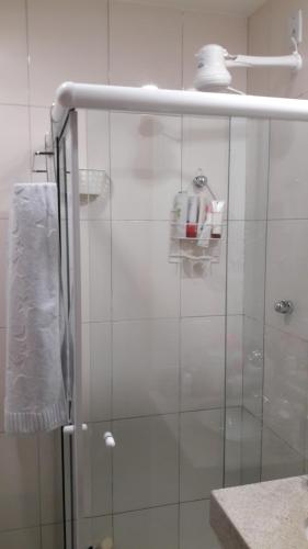 a shower with a glass door and a towel at Quarto e Sala completo in Rio de Janeiro