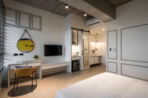 um quarto com uma secretária, uma televisão e uma cama em Tian Zhong Hotel em Tianzhong