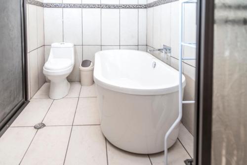 a bathroom with a toilet and a bath tub at Las Calas Lodge in Bajos del Toro