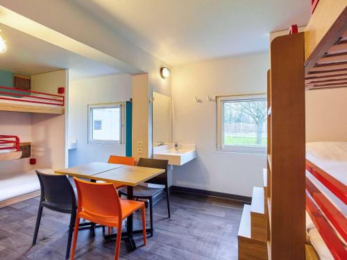 a room with a table and chairs and a bed at hotelF1 Paris Porte de Montreuil in Bagnolet
