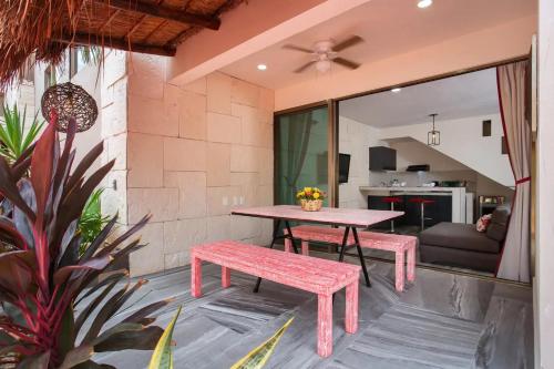 a patio with a table and bench and a living room at Casa Kaoba Hotel & Suites in Playa del Carmen