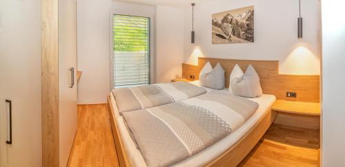 um quarto com uma cama grande e uma janela em Apartments Ella em Innsbruck