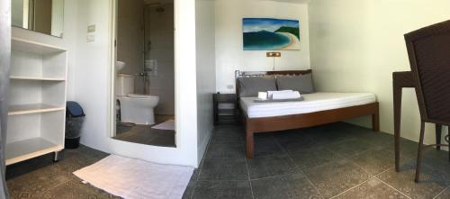 a small bathroom with a bed and a toilet at Victoria's Bed & Breakfast in Puerto Galera