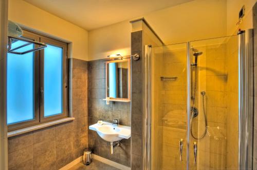 ein Bad mit einem Waschbecken und einer Dusche in der Unterkunft Giga Hotel in Villa Santa Lucia
