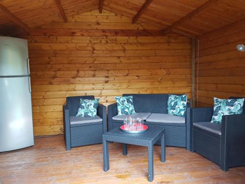 a patio with two chairs and a table and a refrigerator at Villa&Loge in Lontzen