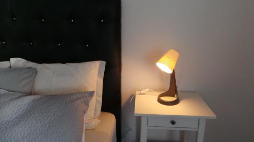 a lamp on a side table next to a bed at 7 Castelos in Oeiras