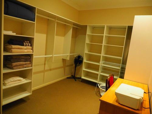 Mount Ommaney的住宿－Accommodation on Westlake Mount Ommaney，客房设有带架子的衣柜和卫生间。