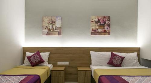 duas camas sentadas uma ao lado da outra num quarto em Lavana Hotel Batu Caves em Batu Caves
