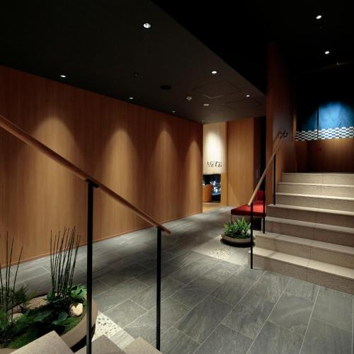 a lobby of a building with stairs and a stair case at Candeo Hotels Osaka Kishibe in Suita