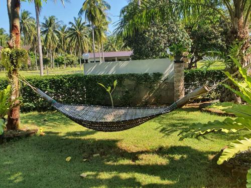 a hammock in a yard next to a house at Happy Mind Resort in Sam Roi Yot