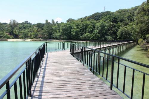 a wooden bridge over a body of water at Nongsa Village in Nongsa