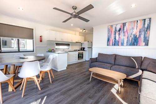 a living room and kitchen with a couch and a table at Barwon River Holiday Park in Geelong