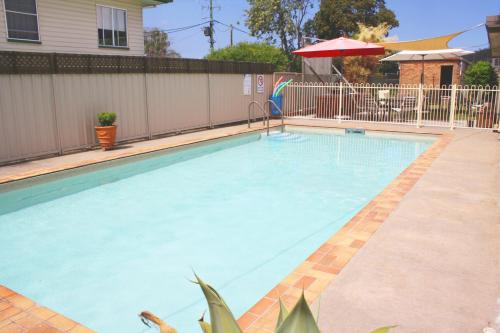 a swimming pool with blue water in a house at Waterview Motel Maclean in Maclean