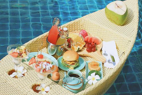 a table with food and drinks on a table by a pool at Anio Boutique Hotel Hoian in Hoi An