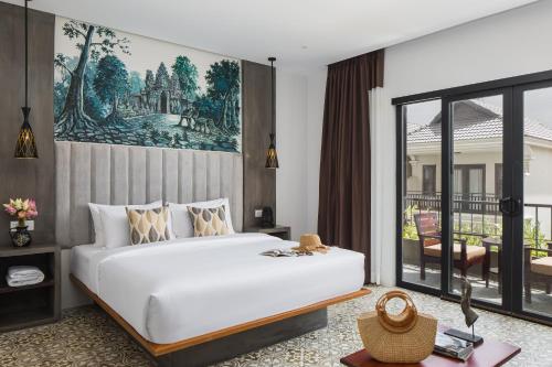a bedroom with a large bed and a balcony at Siem Reap Palace Hotel & Spa in Siem Reap