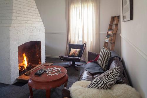 a living room with a couch and a fireplace at Domino House in Trentham