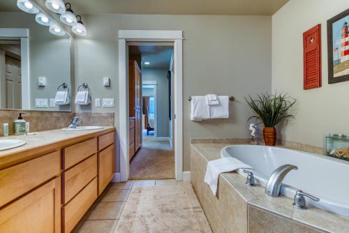 a bathroom with a tub and two sinks and a mirror at River Vista in Florence