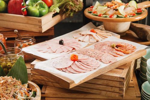 a table with plates of meat and other foods at Anio Boutique Hotel Hoian in Hoi An