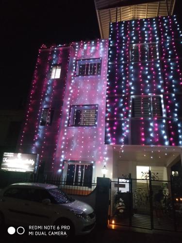 un edificio è illuminato da luci viola e blu di Tranquil AC Comfortable stay for Male onlly a Bhubaneshwar