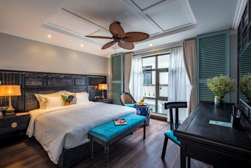 a bedroom with a large bed with a ceiling fan at Anio Boutique Hotel Hoian in Hoi An